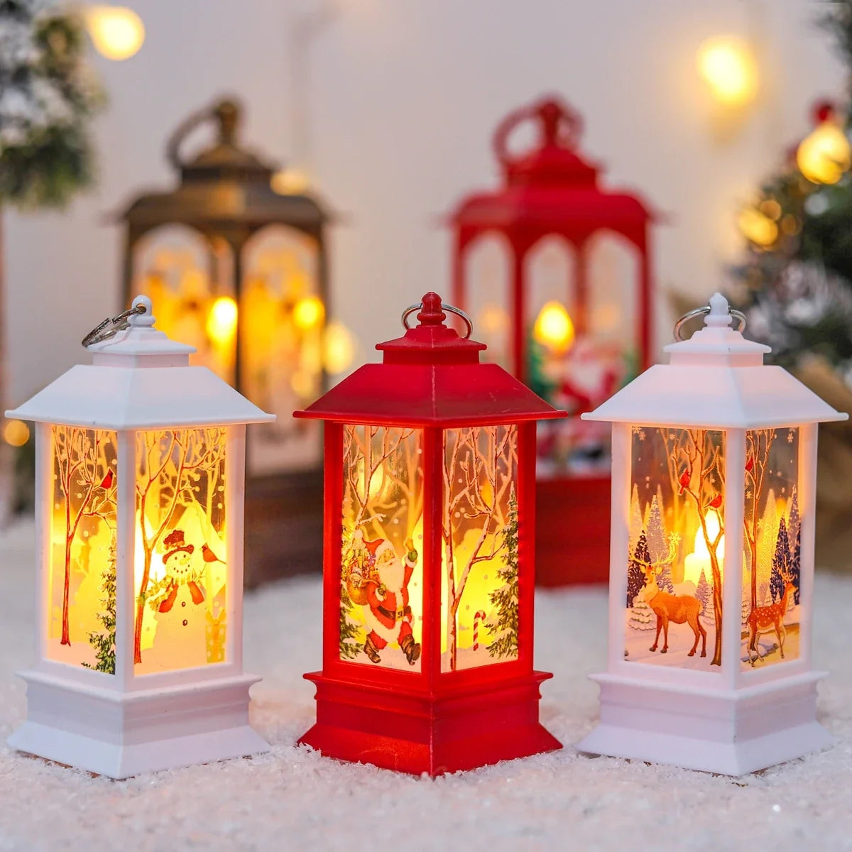 White, red and bronze Christmas scene lanterns glowing warm on a snowy surface