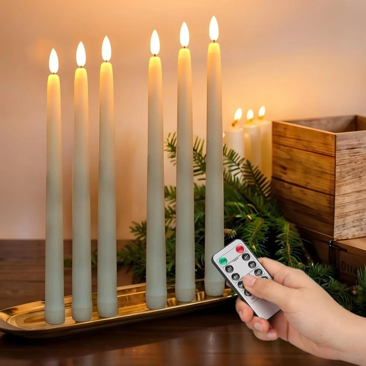 Six flameless LED taper candles glowing on a gold tray beside a remote