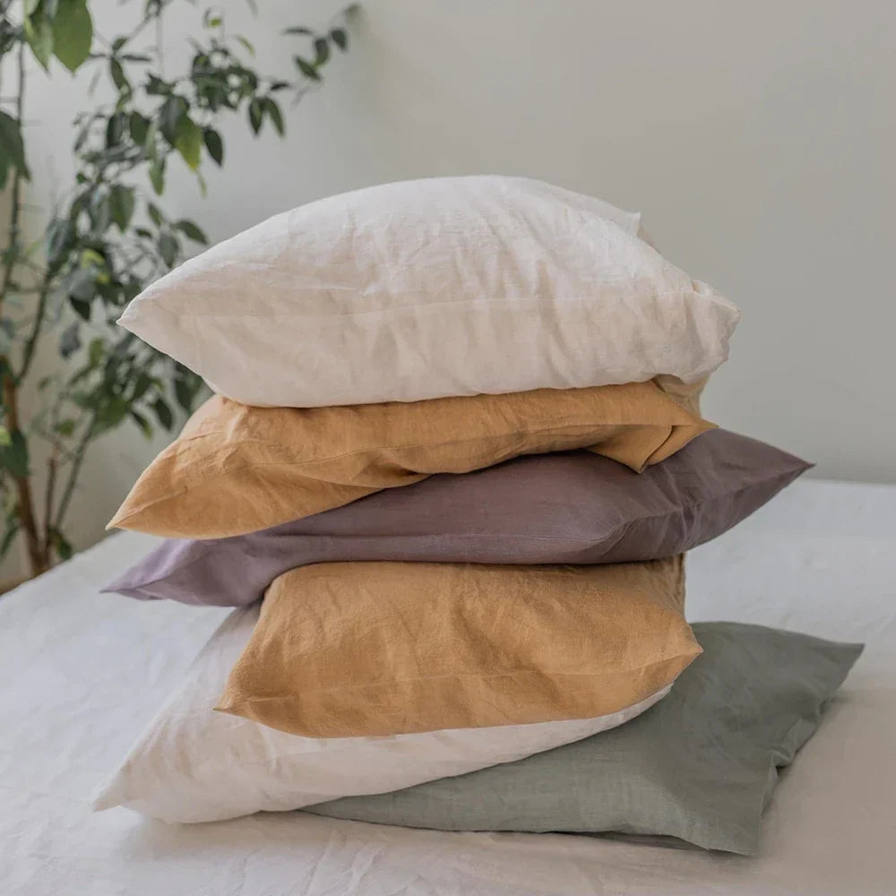 A stack of French flax linen pillowcases in earthy colours