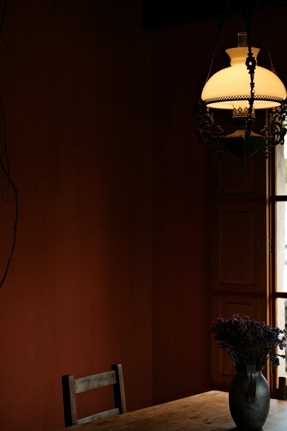 A dimly lit room with a lamp and flowers