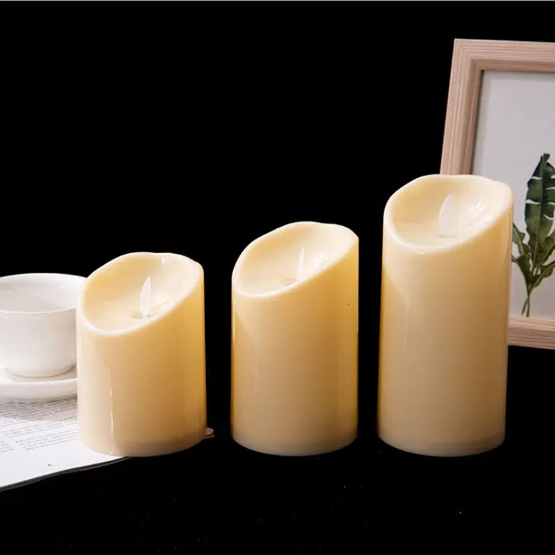 Three flameless LED pillar candles in graduated heights glowing on a table