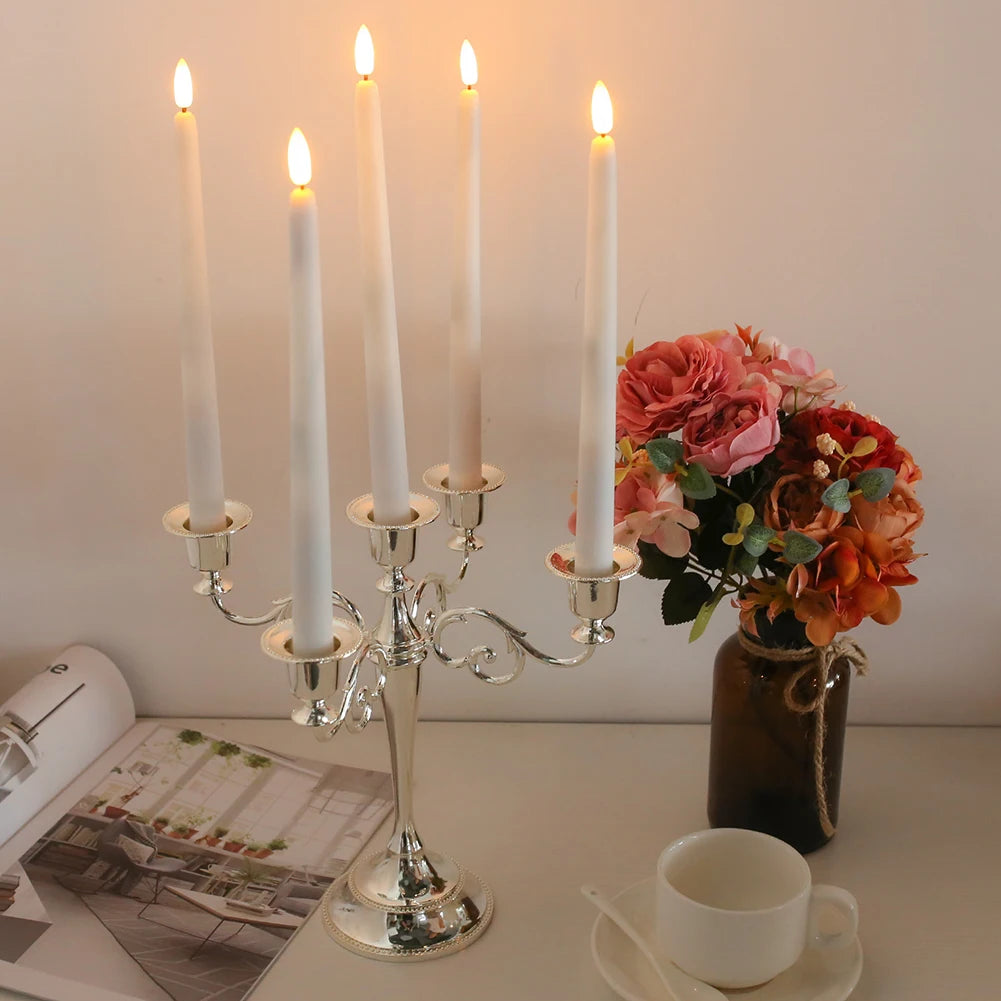Flameless taper candles in a silver candelabra with flowers