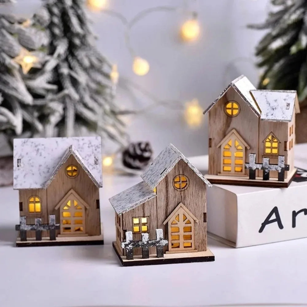 Wooden Christmas cottages lit up beside a small tree and fairy lights