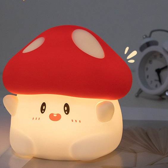 Red mushroom silicone night light glowing on a bedside table